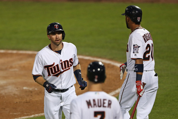 Brian Dozier celebrates with his teammates in Eddie Rosario and Joe Mauer right after hitting a homer during the third inning of the spring training game against the Boston Red Sox