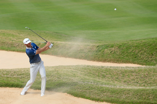 Dustin Johnson takes a swing in the bunker at the Dell Match Play